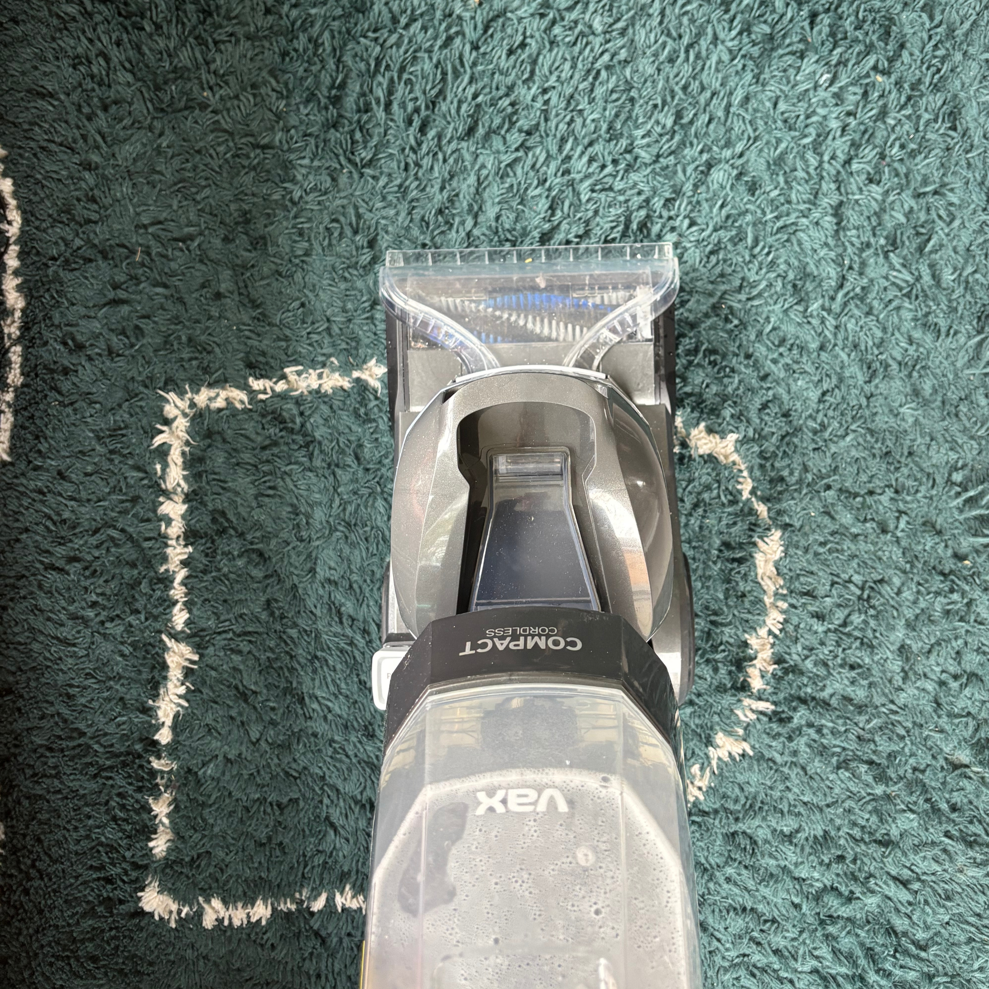 ONEPWR Cordless Compact Carpet Cleaner cleaning a green rug