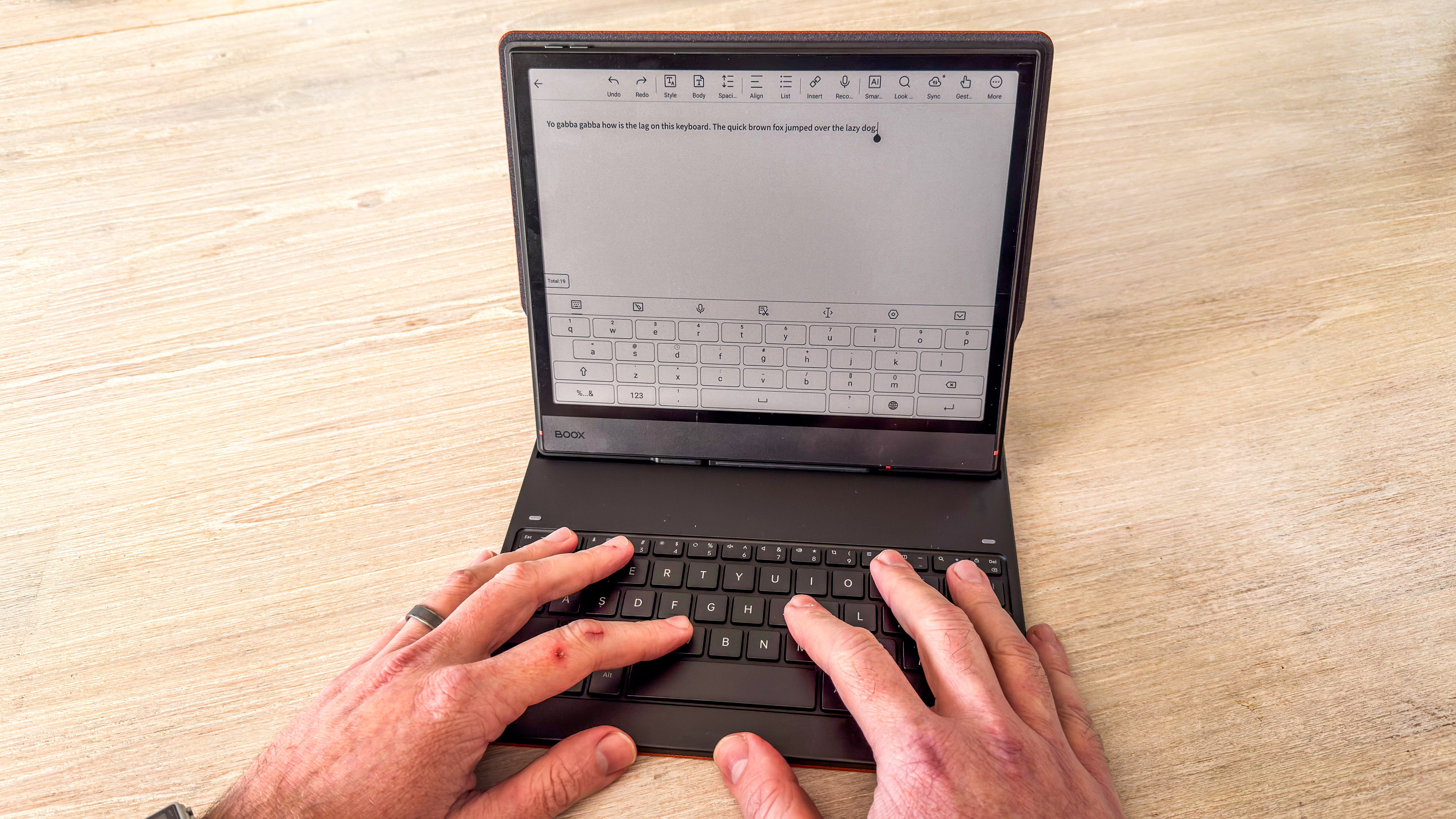 A person using the Boox Note Air5 C with its keyboard folio