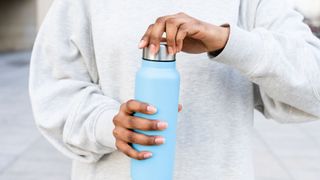 woman holding refillable water bottle