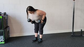Personal trainer Rebecca Stewart performs a dumbbell dual row