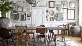 White painted wall panels in danish dining room with mirror gallery wall