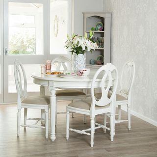 dining area with white round table and chair grey designed wall wooden flooring and white door