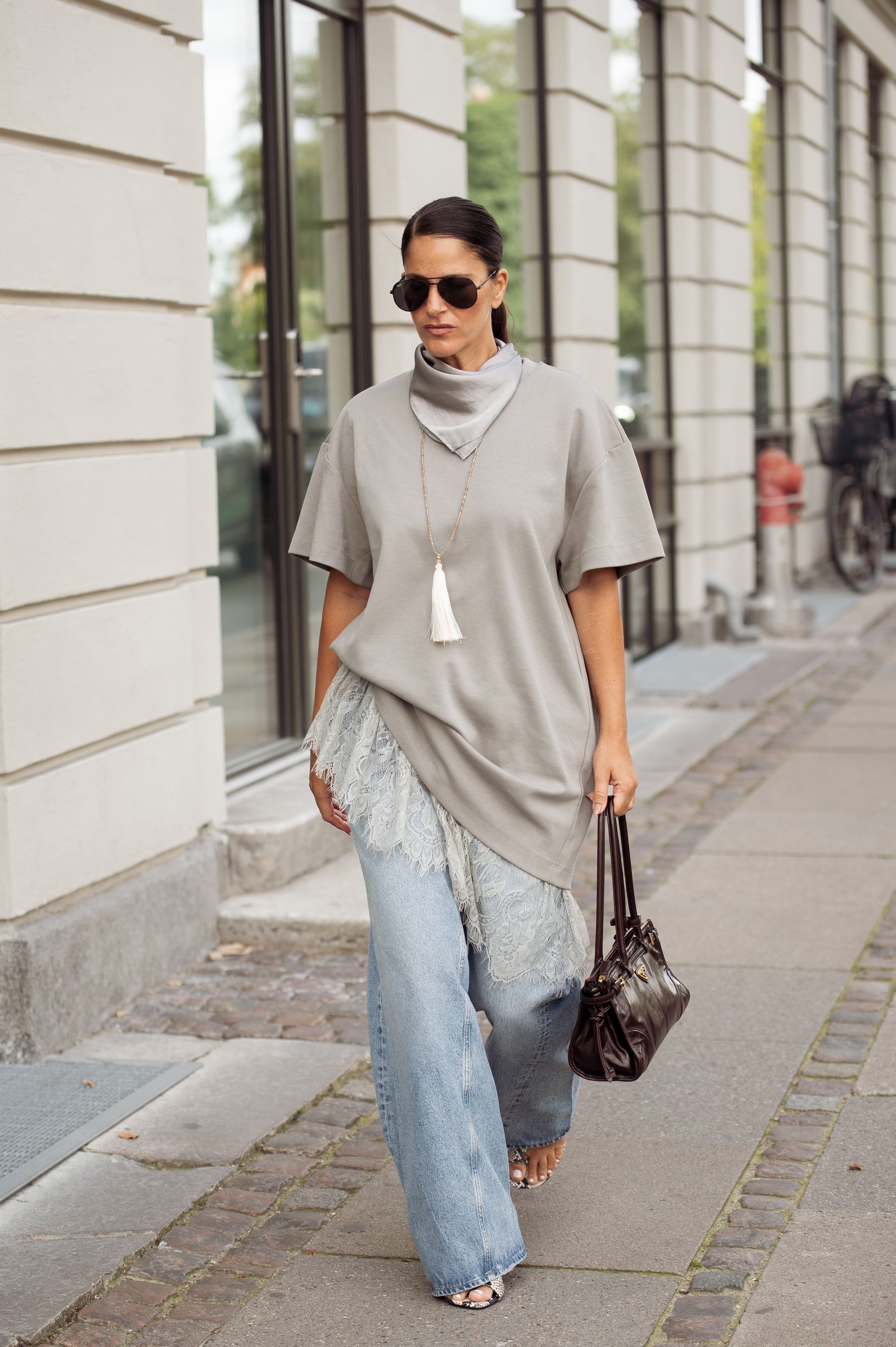 Woman in oversize tee, lace dress and jeans