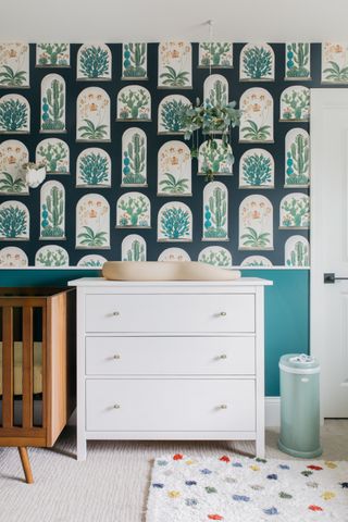 A nursery with a bold black and white wallpaper