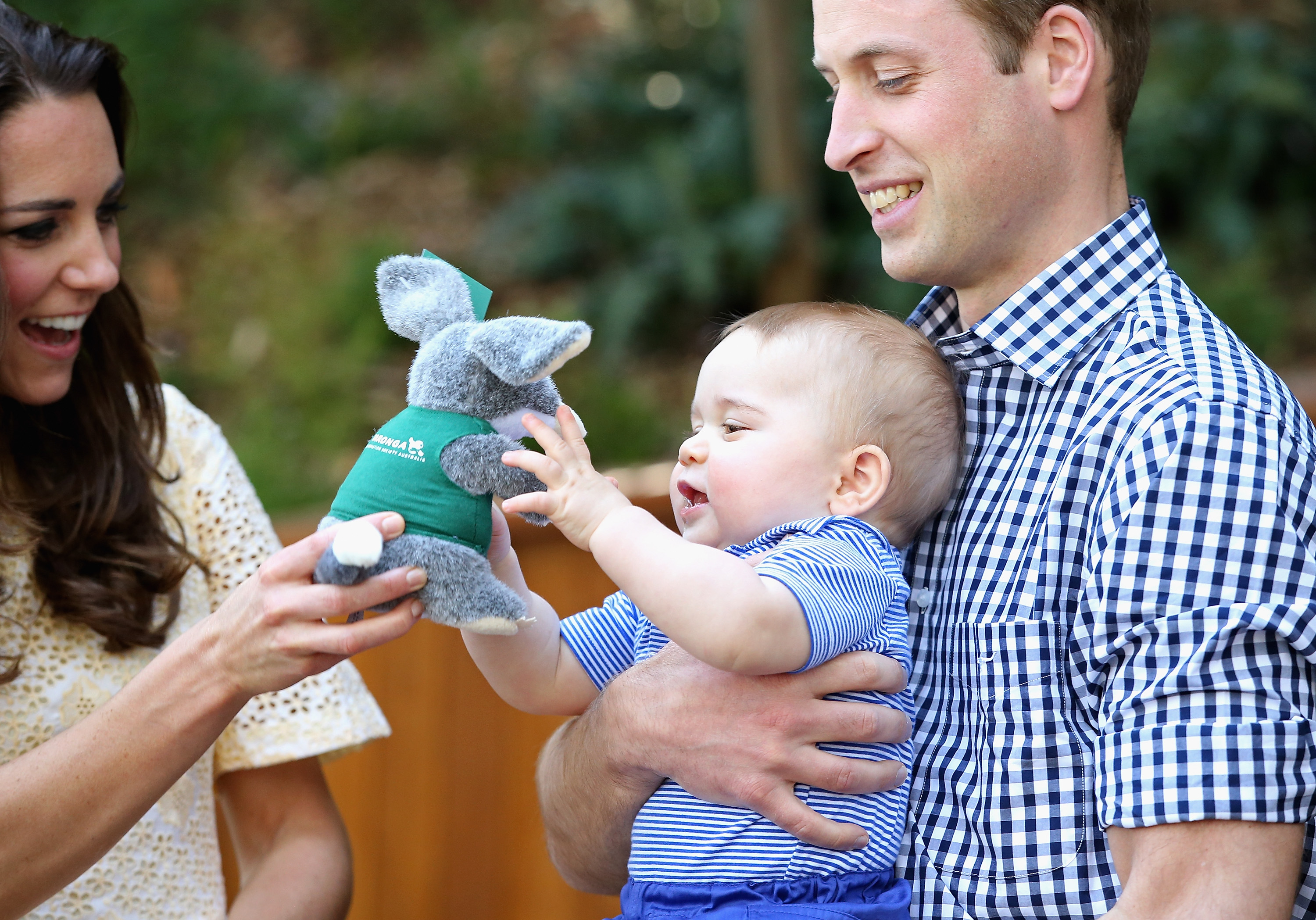 Baby Prince George holding a stuffed bilby toy that Princess Kate is giving him