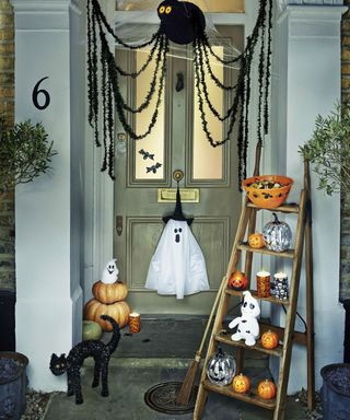 house with wooden door and halloween decorating items with pumpkins