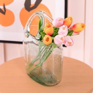 A bouquet of artificial tulips in a clear vase on a table