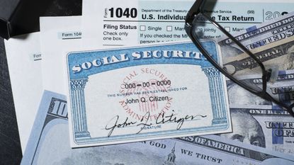 A Social Security card sits on top of cash and tax returns.