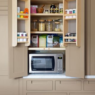storage shelves with groceries and microwave