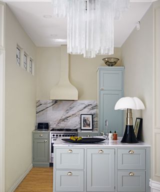 Blue drawers and cabinets, marble backsplash, cream walls