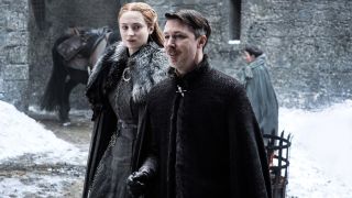 Aidan Gillen standing in front of Sophie Turner on Game of Thrones