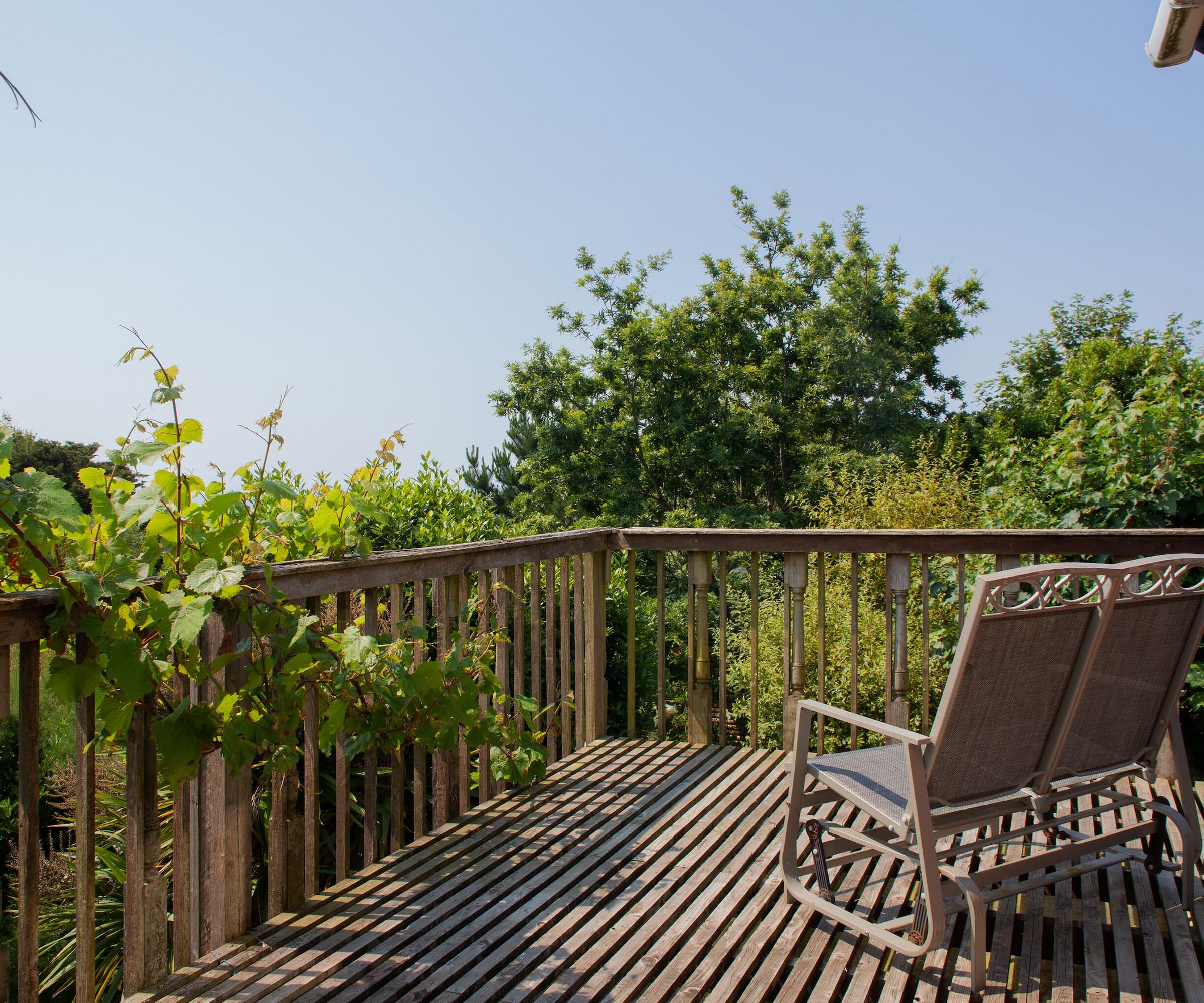 A wooden balcony with views over treetops