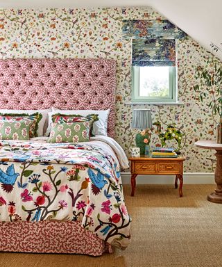colorful bedroom with floral wallpaper, patterned headboard, bedding beige carpet