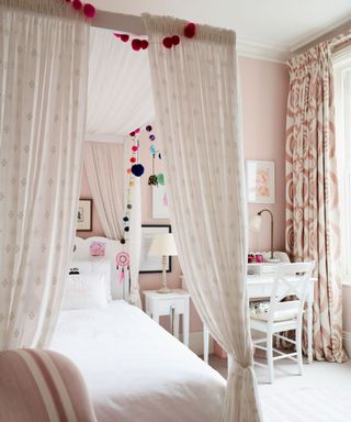 Pink walls, four poster bed, white desk