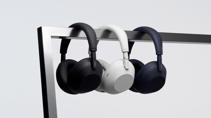 Sony WH-1000XM6 headphones in black, white and blue hung over a bar.