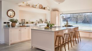 kitchen extension with large picture window and pale pink fitted kitchen with large central island