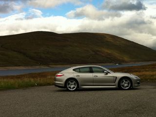 Silver car in front of large hills