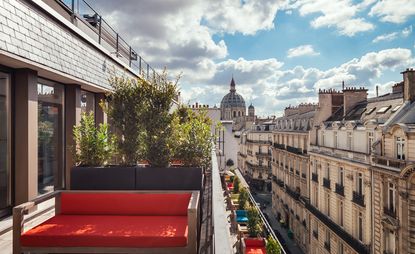 Balcony in Paris with red and wood sofa overlooking the street