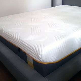 The Tempur Sensation Elite mattress om a grey upholstered bed frame