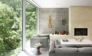 Poured-in-situ concrete is accompanied by oak millwork, a travertine fireplace and a soft white plaster exterior.