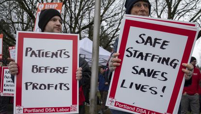 Kaiser Permanente healthcare workers hold picket signs outside an Oregon hospital in January 2023.
