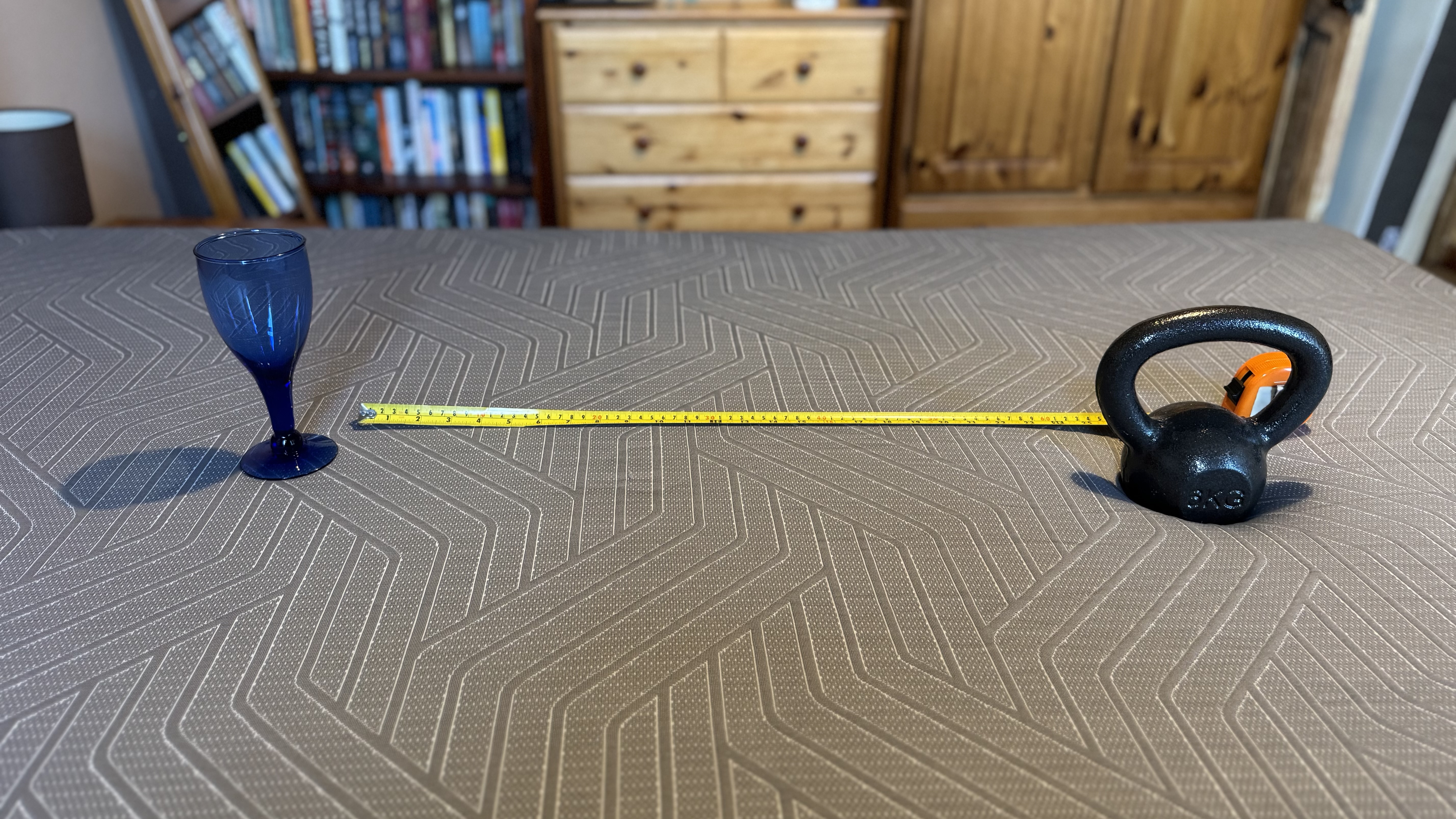 A wine glass, tape measure and weight to measure motion transfer on the EGOHOME Hybrid mattress.