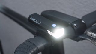 A 3/4 front view of a bike light that is switched on