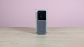 UGREEN Nexode Power Bank 20000mAh 165W leaning on plinth on desk with pink background