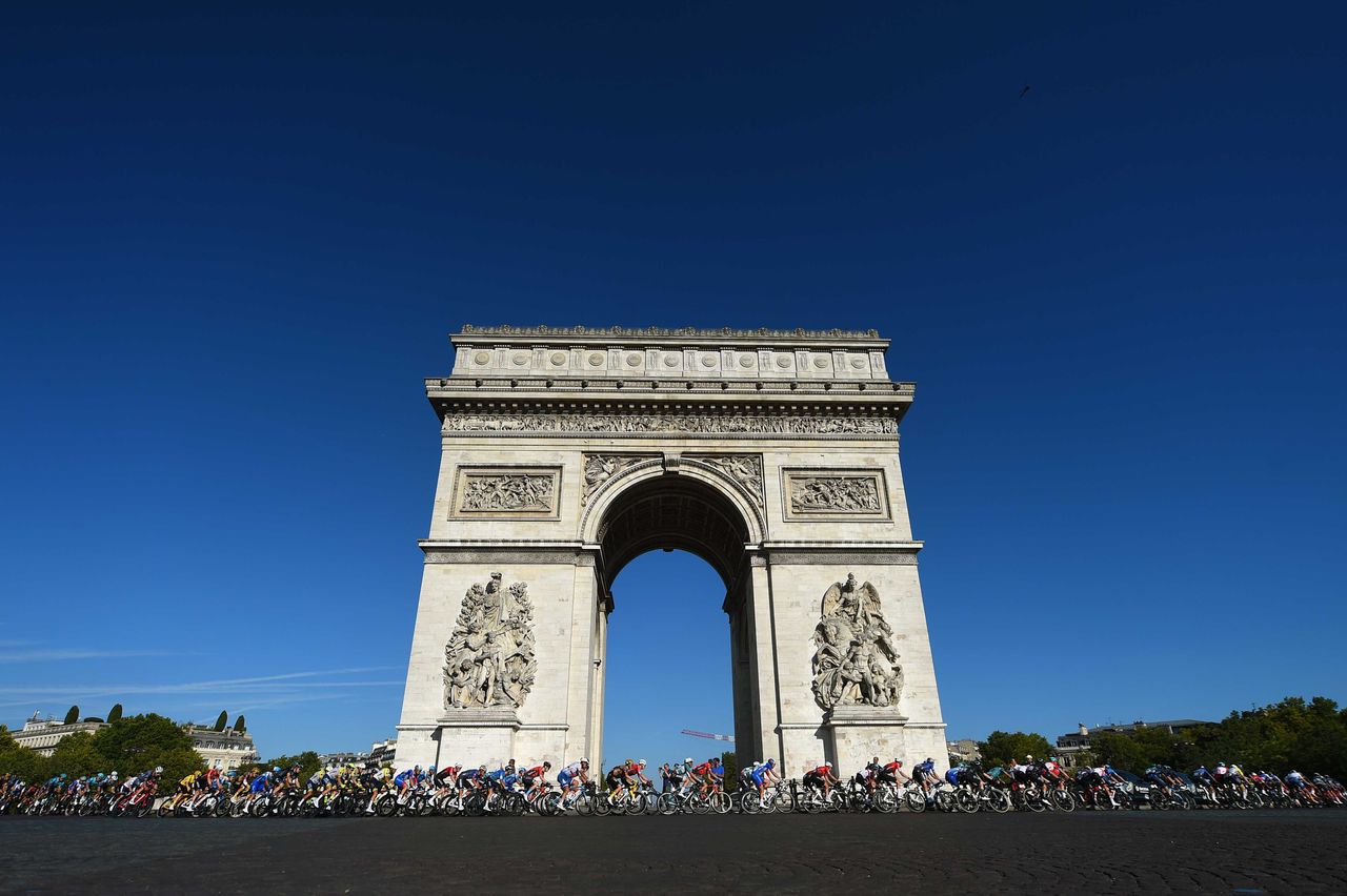 The Tour de France peloton rounds the Arc de Triomphe