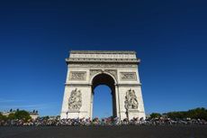 The Tour de France peloton rounds the Arc de Triomphe