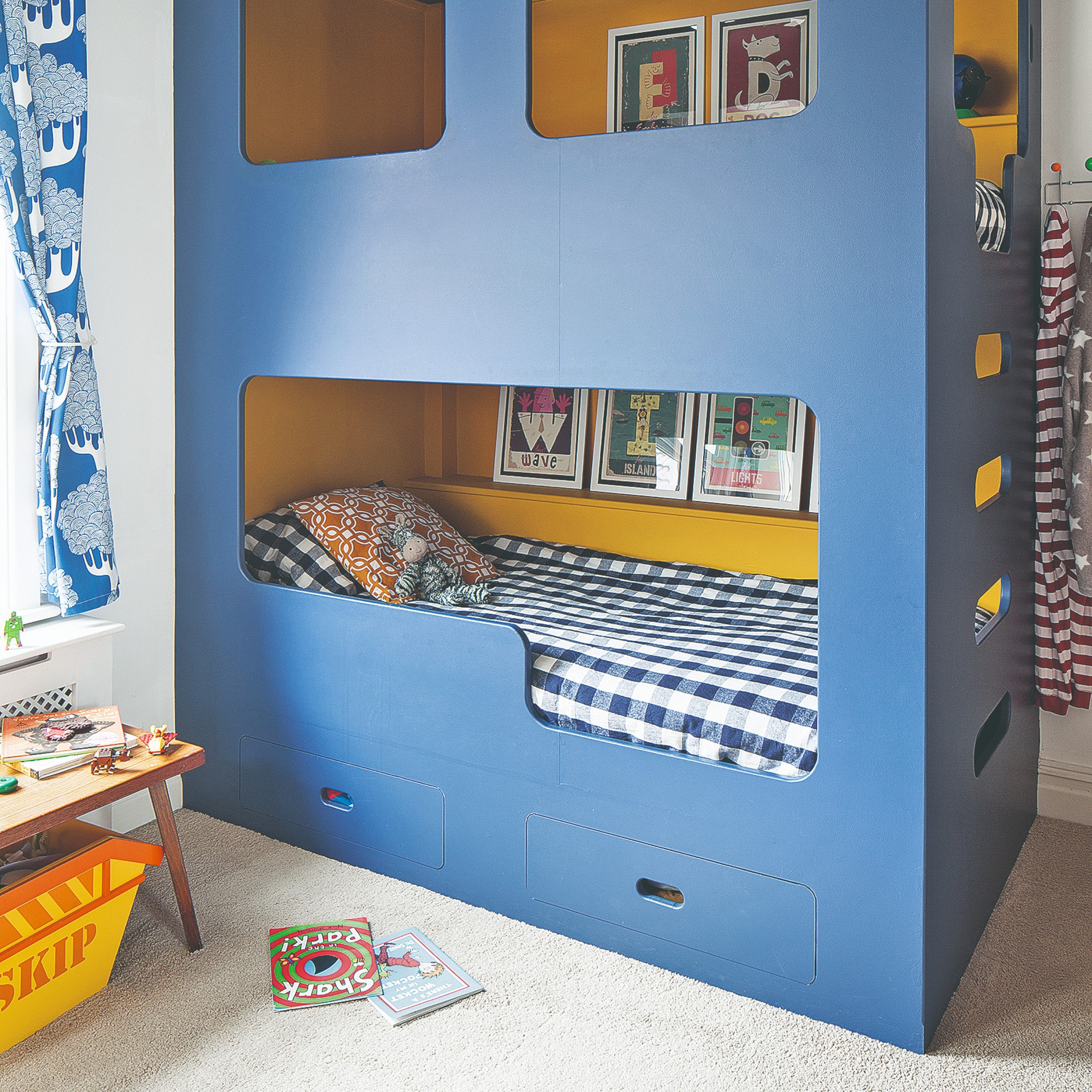 A children's room with a blue bunk bed with built-in storage