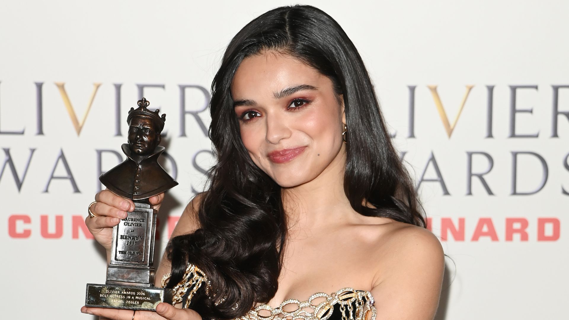an image of Rachel Zegler winning Best Actress in a Musical award for Evita at The Olivier Awards 2026,  posing with her award at the 2026 awards in London
