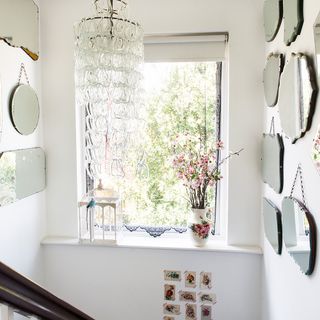 room with round mirror white vase and white wall