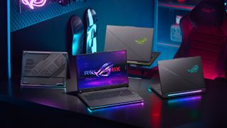Four Asus ROG Strix gaming laptops set up on a desk.