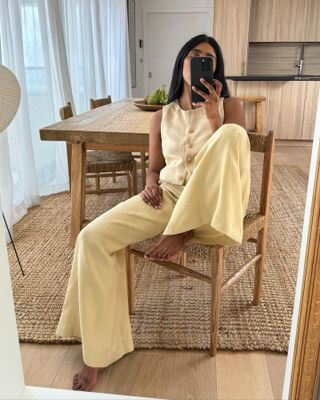 Woman taking a mirror selfie wearing a butter yellow matching set.