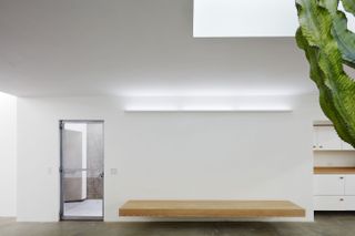 Emeco House main entrance with wooden wall mounted bench and bright skylight above