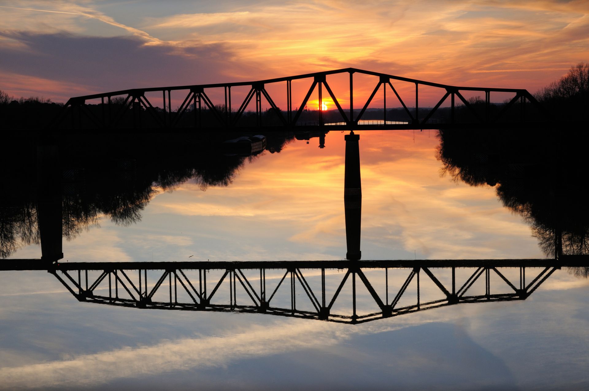 A truss bridge over a river at sunset in Northport.