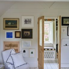 A bedroom painted in Farrow & Ball's Wimborne White shade with one wall dedicated to a gallery wall
