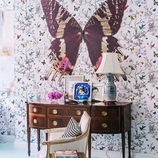 room with large butterfly sticker and patterned wallpaper