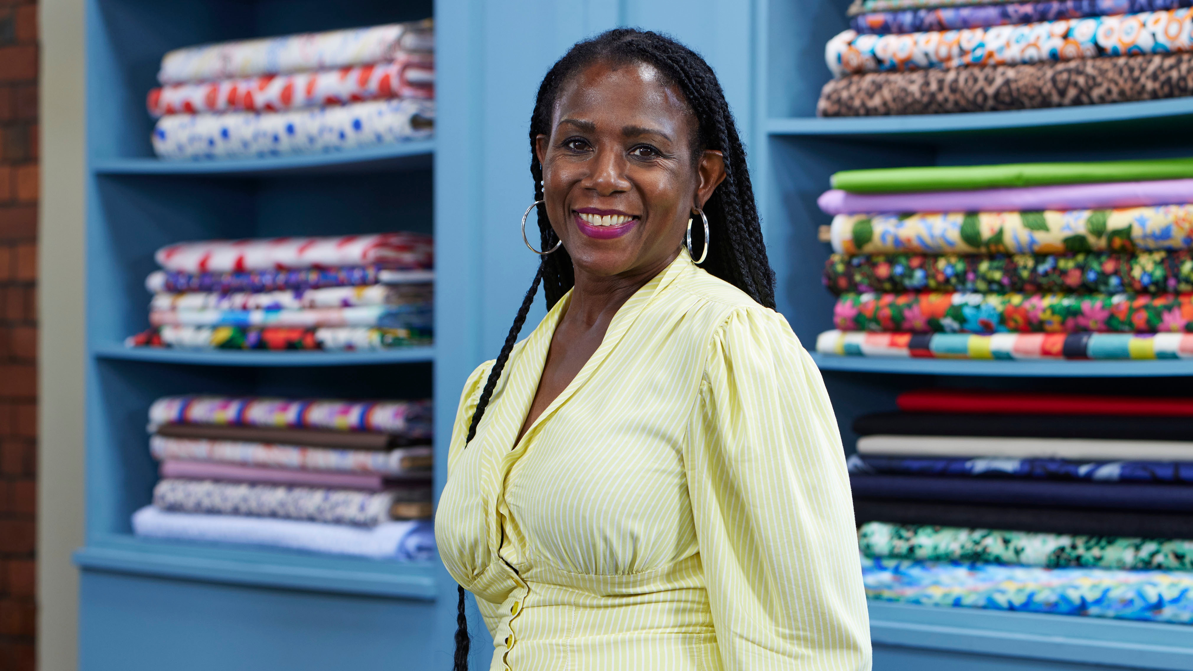 Glendora standing in the Great British Sewing Bee studio and smiling for the camera