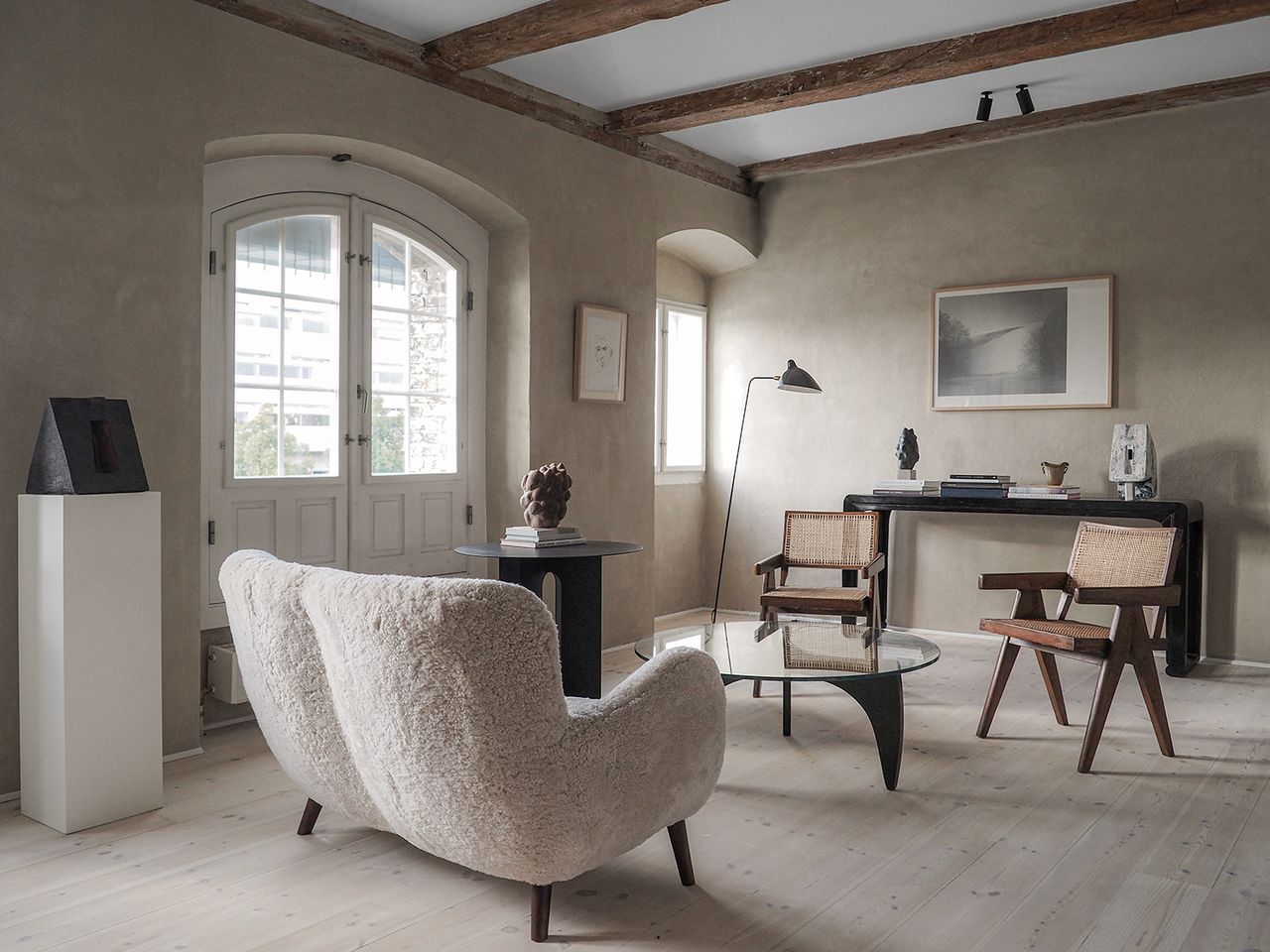 minimaluxe living room with wood floors, grey limewash walls and white couch