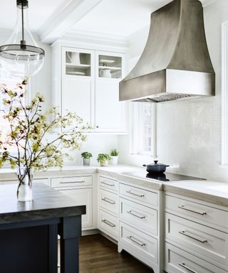 kitchen with white cabinets and steel hood