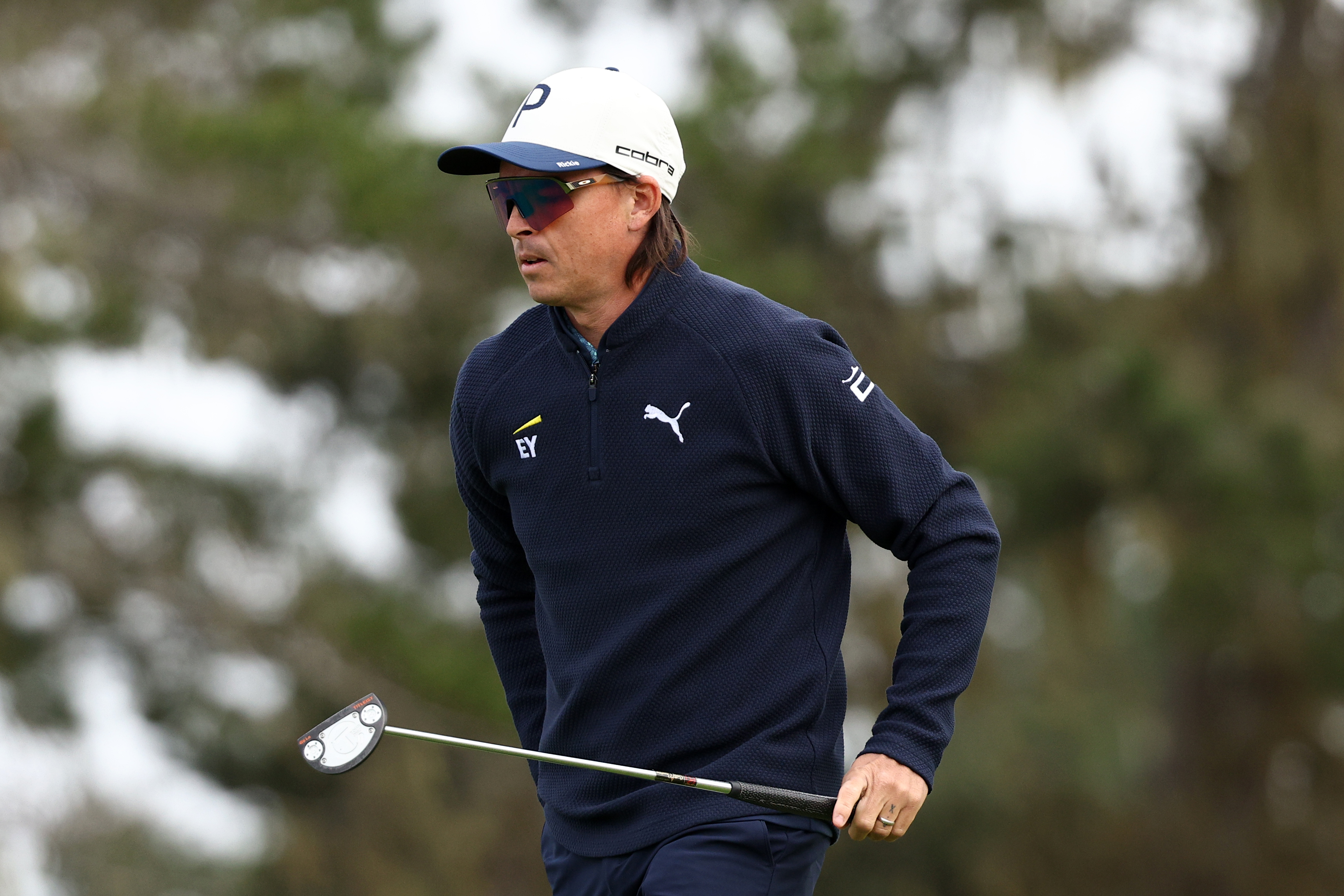 Rickie Fowler walks off the green holding a putter