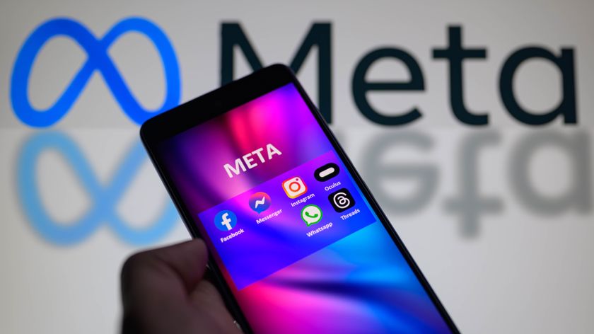 Meta social media icons are being displayed on a smartphone among Facebook, Messenger, Instagram, Threads, and other products, with the Meta icon visible in the background.