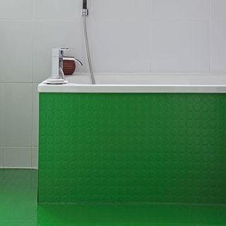 bathroom with white wall and green bathtub