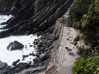 A landscape photo of a balcony with chairs and tables on the cliff-edge.