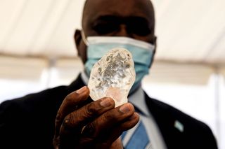 Botswana President Mokgweetsi Masisi (R) holds a gem diamond in Gaborone, Botswana, on June 16, 2021.