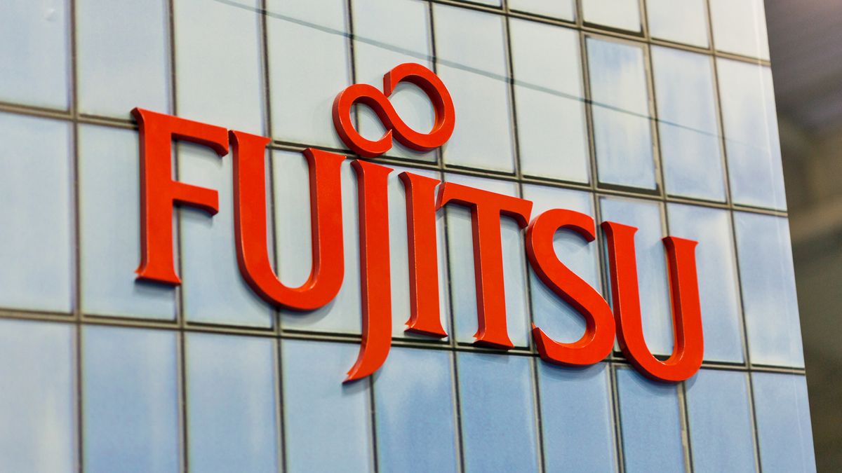 Red Fujitsu signage on side of glass building