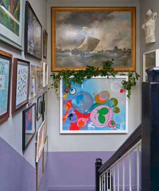 staircase with lavender and gray walls and gallery wall