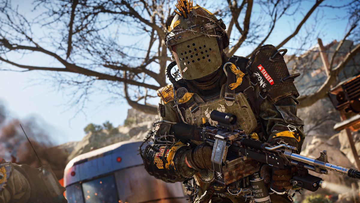 Best Warzone stoner 63 loadout - a Warzone operator stands with an armoured face guard and the words &#039;danger zone&#039; on his arm.